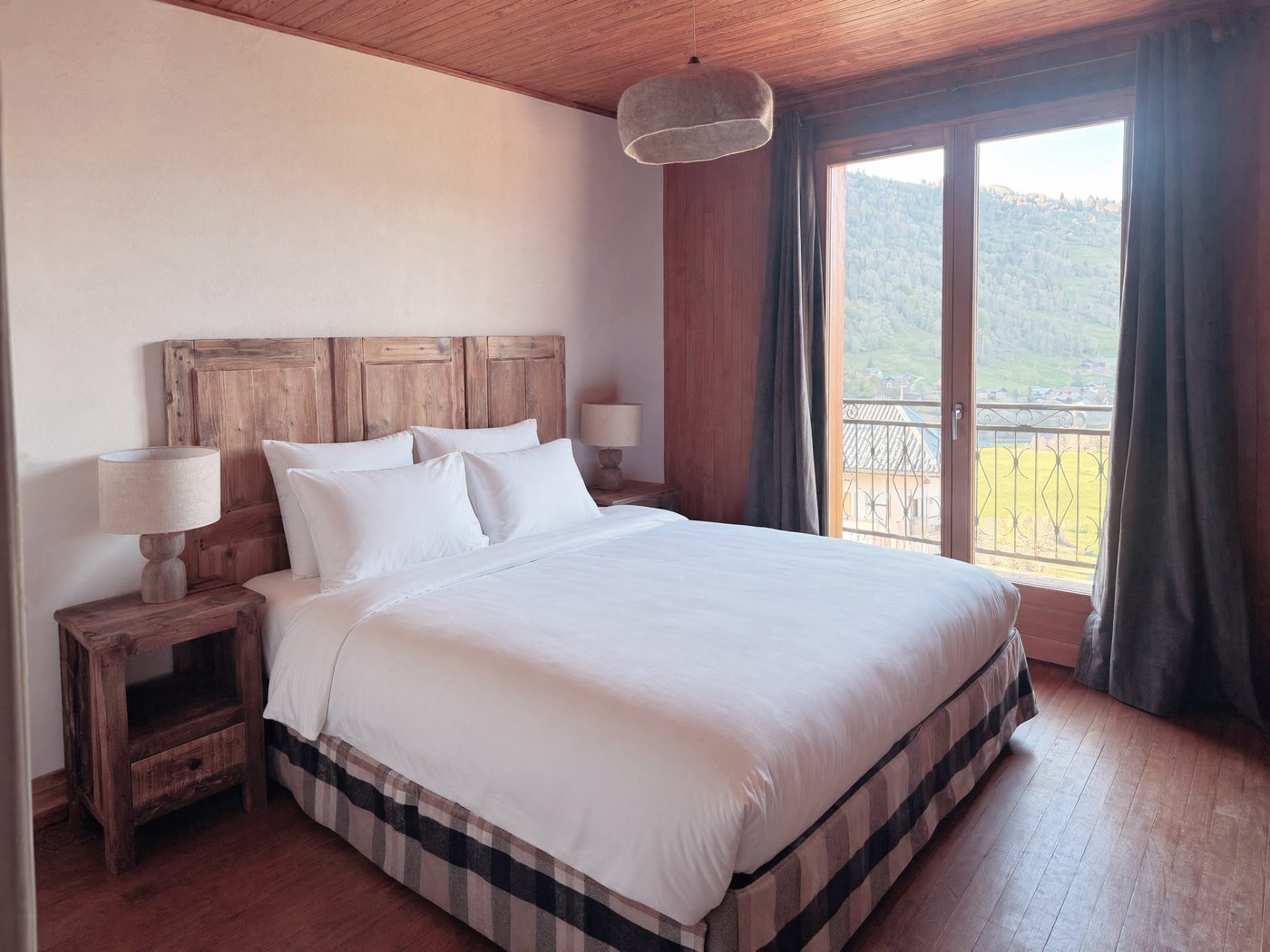 Chambre Queen, tête de lit en vieilles portes et vue sur la vallée
